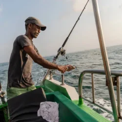 fisherman-preparing-the-fishing-equipment-attaching-a-bait-aboard-a-boat-during-the-deep-sea